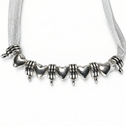 silver charm featuring heart-shaped charms and textured spiral spacers, displayed on a white ribbon against a white background.