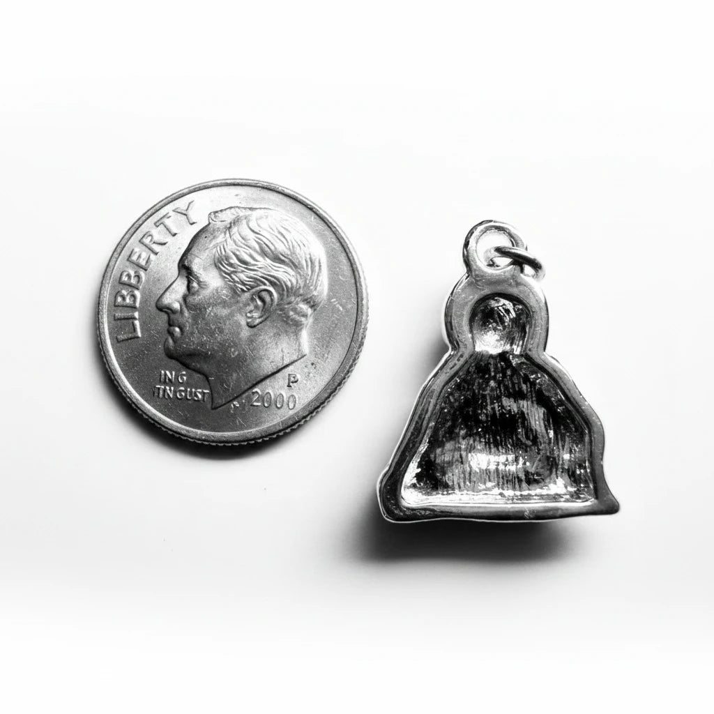A small silver bell-shaped pendant with a polished reflective finish, shown next to a US quarter coin for scale on a plain light background.