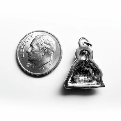 A small silver bell-shaped pendant with a polished reflective finish, shown next to a US quarter coin for scale on a plain light background.