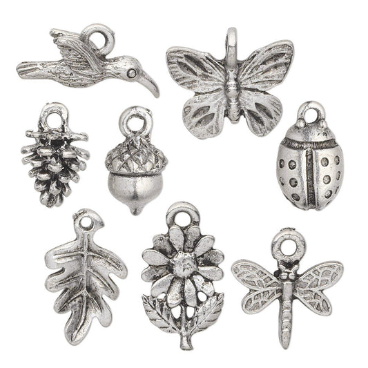 A set of nine silver-toned metal charms with antique finish, featuring nature-inspired designs like a bird, butterfly, pine cone, acorn, ladybug, oak leaf, flower, and dragonfly, arranged on a plain white background.