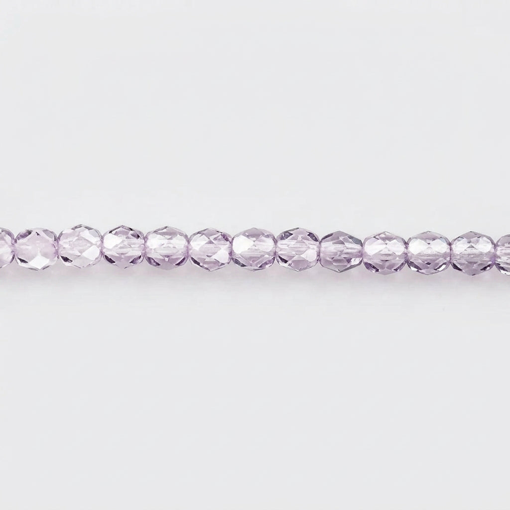A single strand of faceted round beads in a light lavender purple color, laid horizontally against a plain white background.