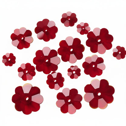 Red flower-shaped craft sequins with a faceted, multi-point design and a central hole, scattered on a plain white background.