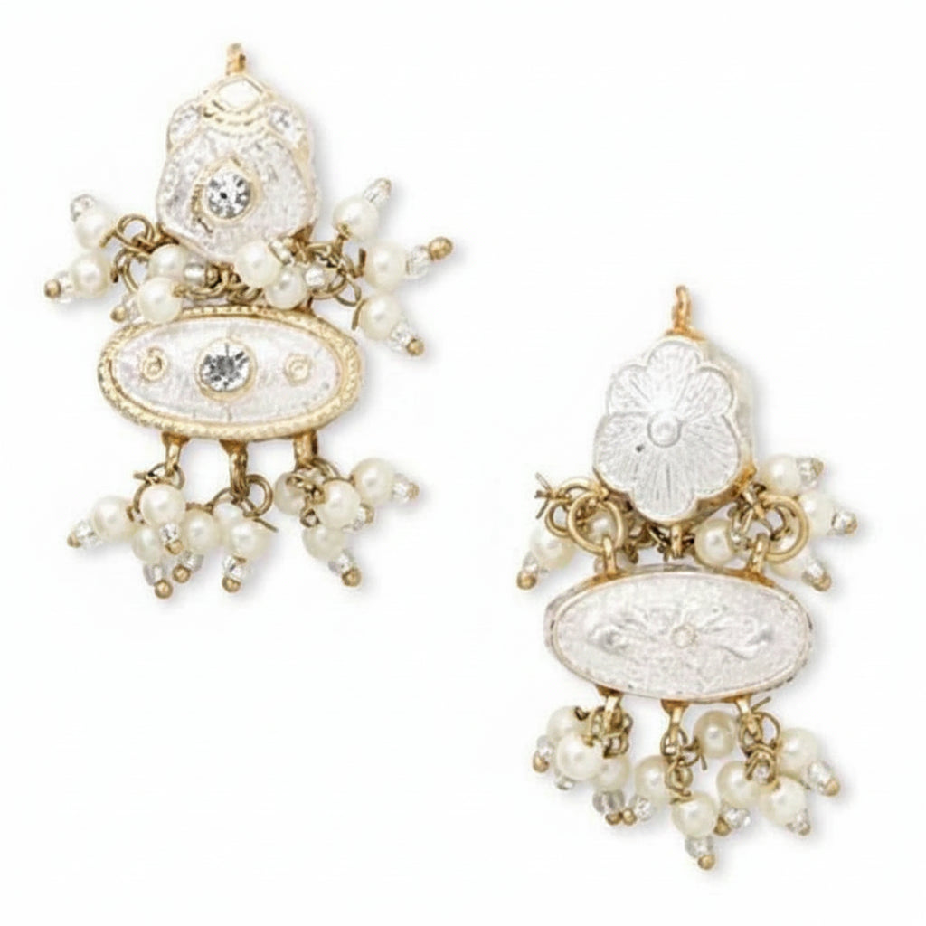 A pair of ornate gold-plated jhumka earrings embellished with white faux pearls, silver-toned stones, and a central round clear crystal, shown against a plain white background.
