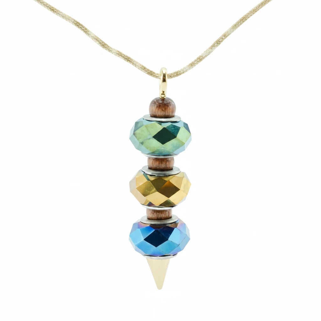A beaded pendant necklace with faceted beads in green, gold, and blue, suspended from a thin gold cord. The pendant features small brown wooden beads and a gold cone tip.