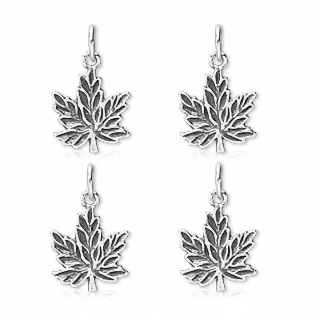 Four silver maple leaf dangle earrings on a plain white background.