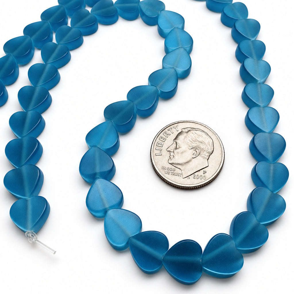 Blue heart-shaped beads strung on a cord, shown with a U.S. dime for scale on a white background.