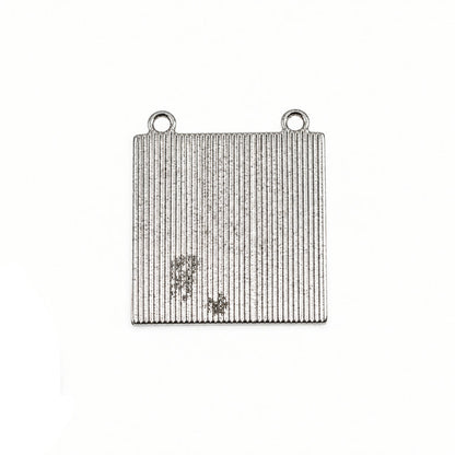 A square silver metal jewelry finding with two loops at the top and a vertically ribbed texture, shown next to a US quarter for scale on a white background.