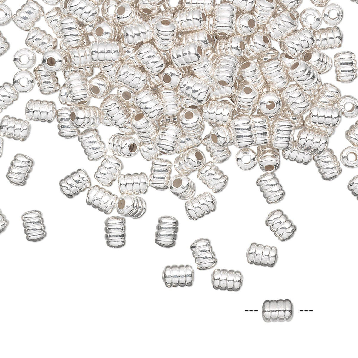 A pile of small silver-colored metallic spacer beads with a ribbed, barrel-like design, scattered on a plain white background with one bead shown separately at the bottom right.