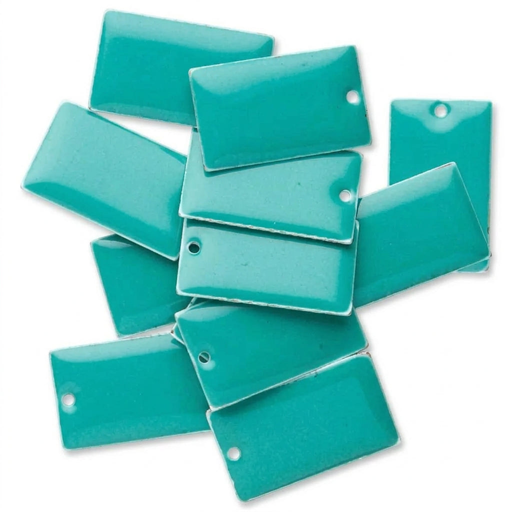 A pile of glossy rectangular turquoise beads with pre-drilled holes, shown on a plain white background.