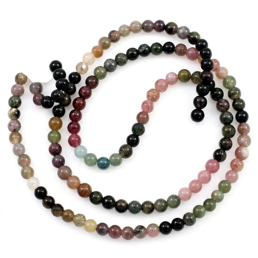 A beaded strand necklace made of faceted round gemstone beads in multiple colors including black, pink, green, brown, and white, coiled on a plain white background.