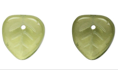 Pair of green leaf-shaped  beads on a white background