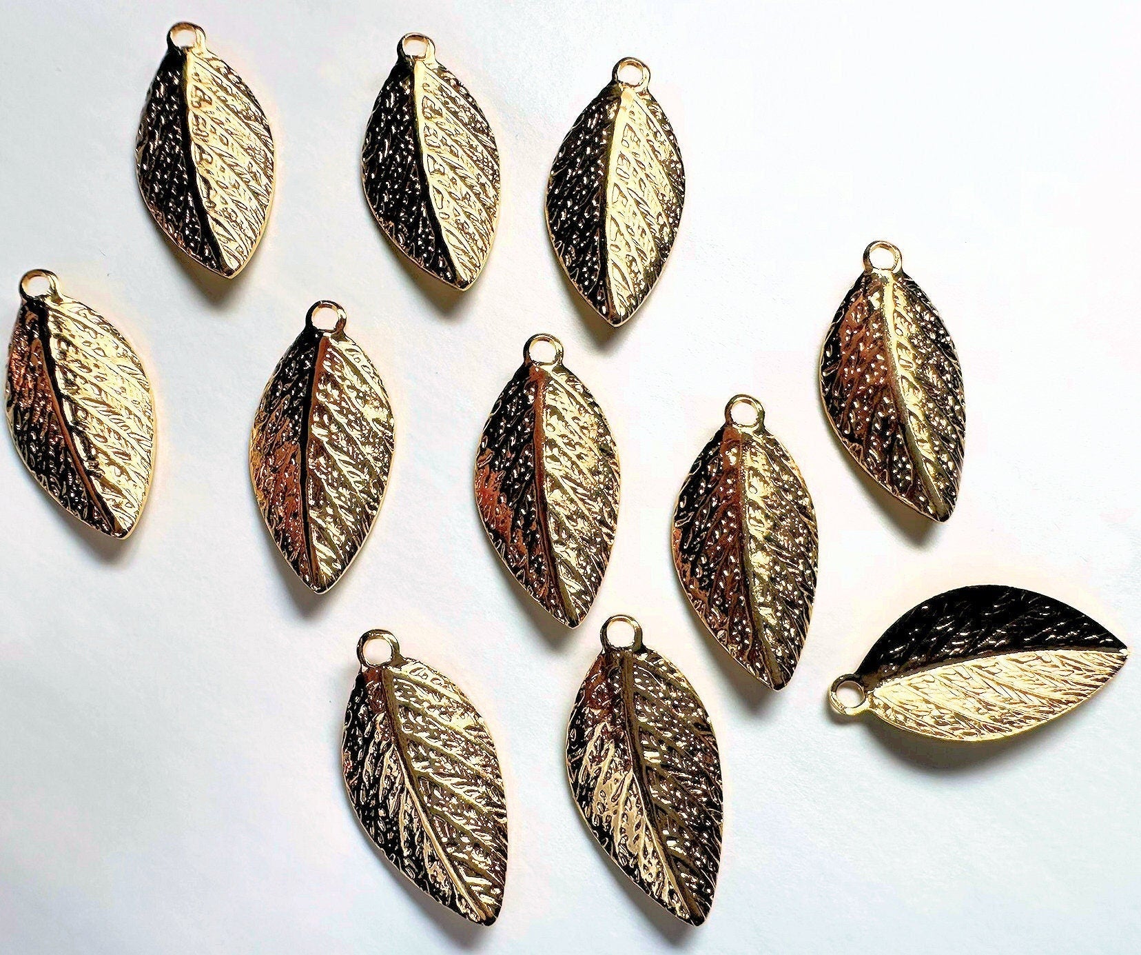 Gold leaf-shaped pendants on a white background