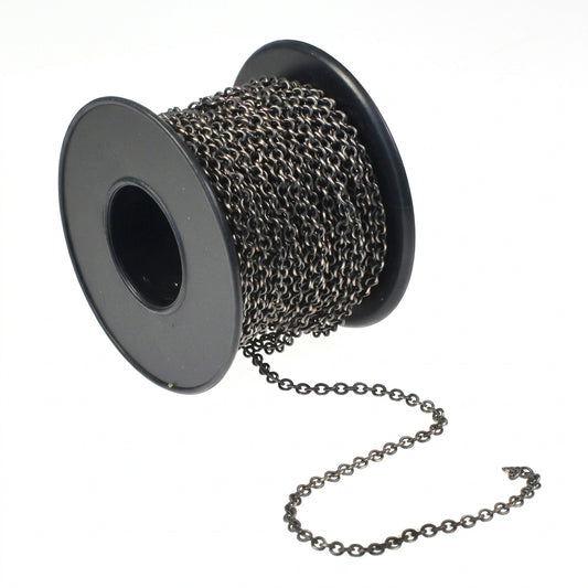 A spool of antique bronze metal chain with a short length of the chain draped out in front, set against a plain white background.