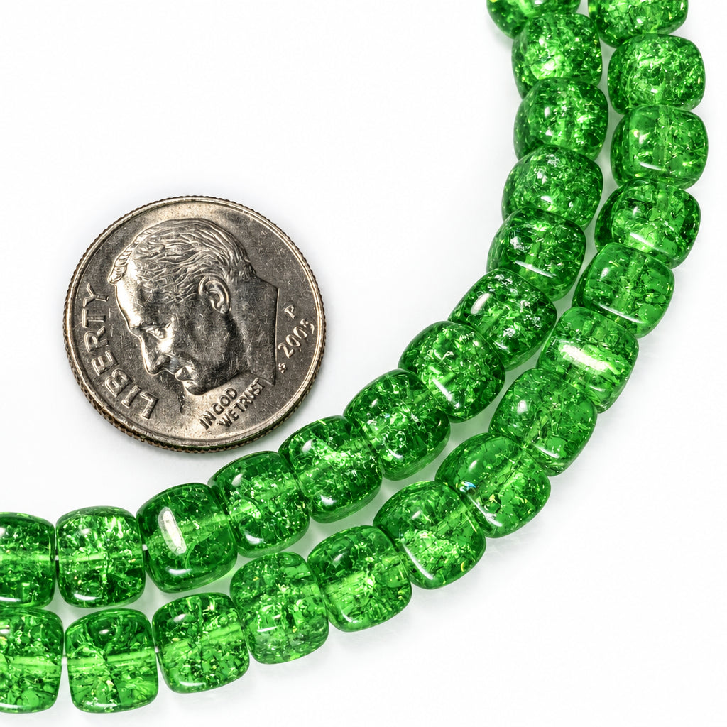 A close-up of a strand of green translucent beaded jewelry laid on a white surface next to a U.S. dime for scale.
