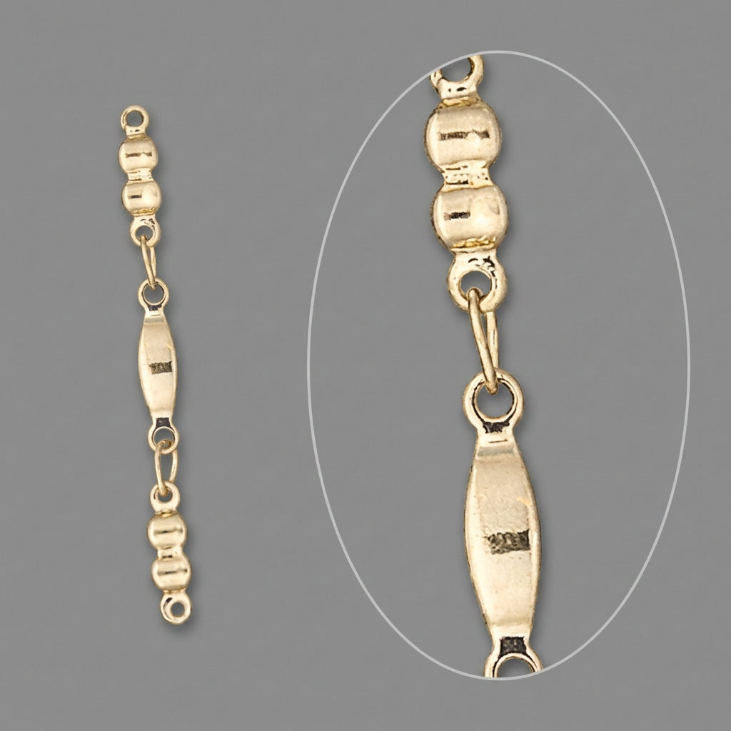 Gold chain link detail showing a close-up of a section with a small oval tag, on a solid gray background.