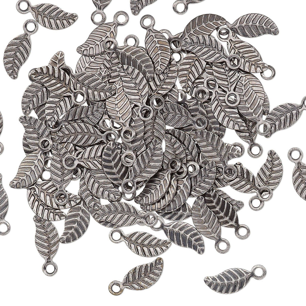 A pile of silver-toned metal leaf charms with textured veining and small loop openings, scattered on a plain white background.