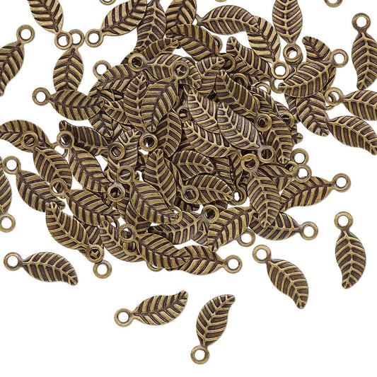 A pile of small leaf-shaped metal charms with loop tops, shown on a plain white background.