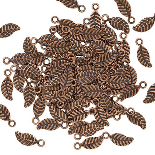 A pile of small leaf-shaped metal charms with loop tops, shown on a plain white background.