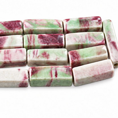Rectangular bar beads with a pink, white, and light green marbled pattern, shown next to a silver coin for scale.