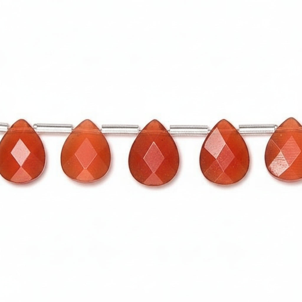 Faceted teardrop-shaped orange-red beads strung on a silver wire, shown against a plain white background.