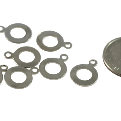 Ten small silver metal ring jump rings with attachment loops, displayed on a white background with a millimeter ruler at the bottom for scale and a coin on the right for size reference.