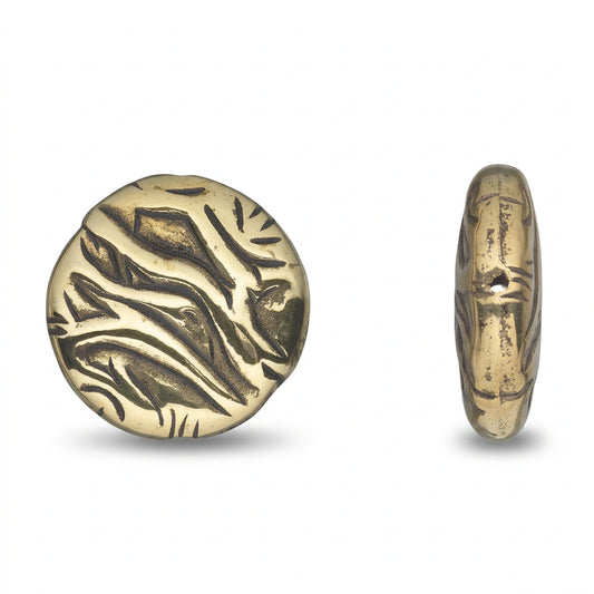 A round metallic pendant or coin-like piece with engraved abstract leaf-like patterns, shown from the front and side on a plain white background.