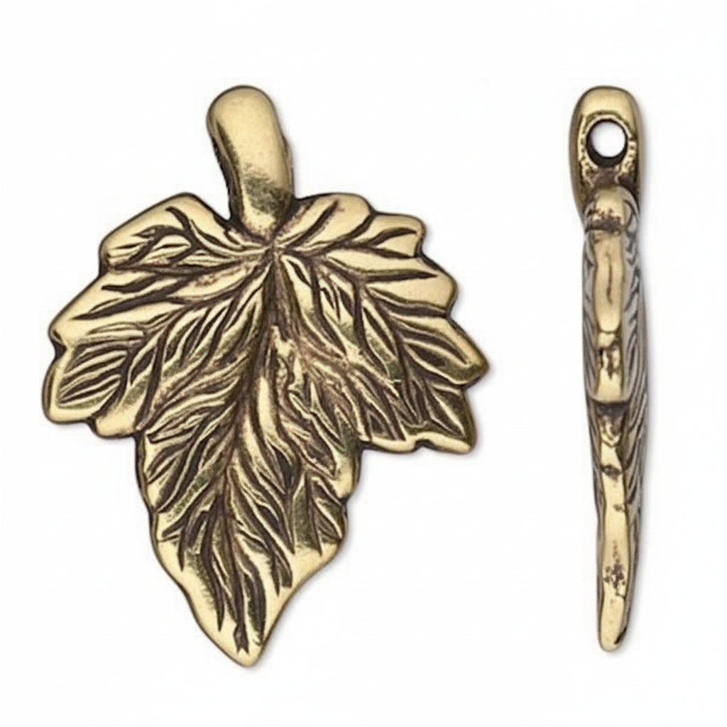 An antique bronze metal leaf-shaped charm with an attached bail, shown alongside its side profile view on a plain white background.