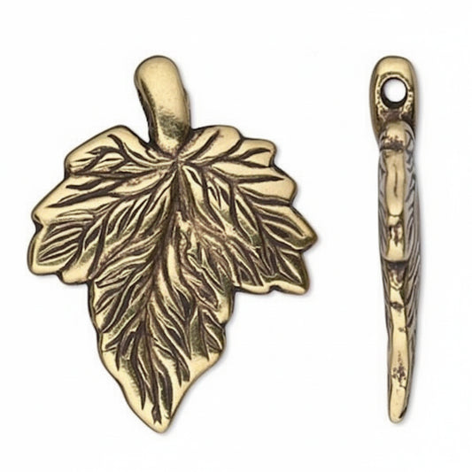 An antique bronze metal leaf-shaped charm with an attached bail, shown alongside its side profile view on a plain white background.