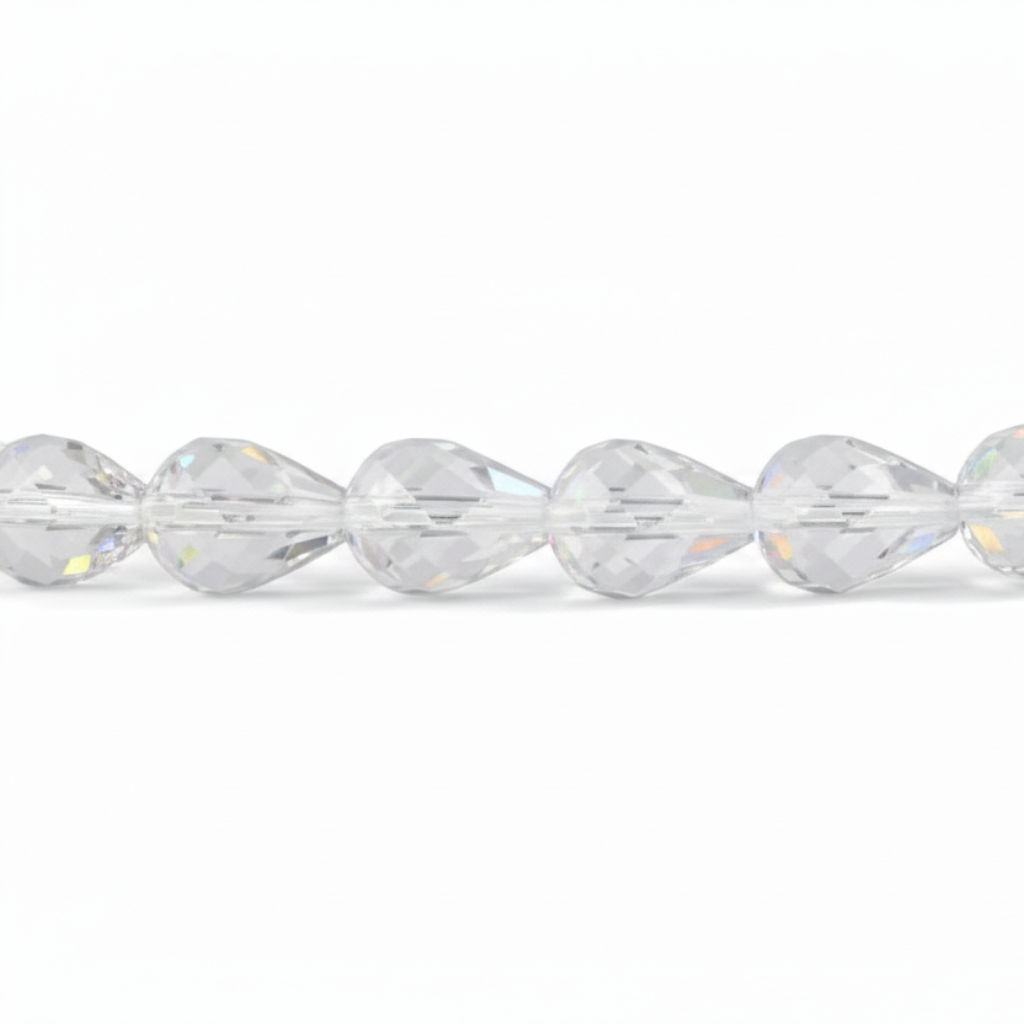 A close-up of a faceted clear bead strand, showing multiple transparent teardrop-shaped beads with prismatic cuts reflecting light on a white background.