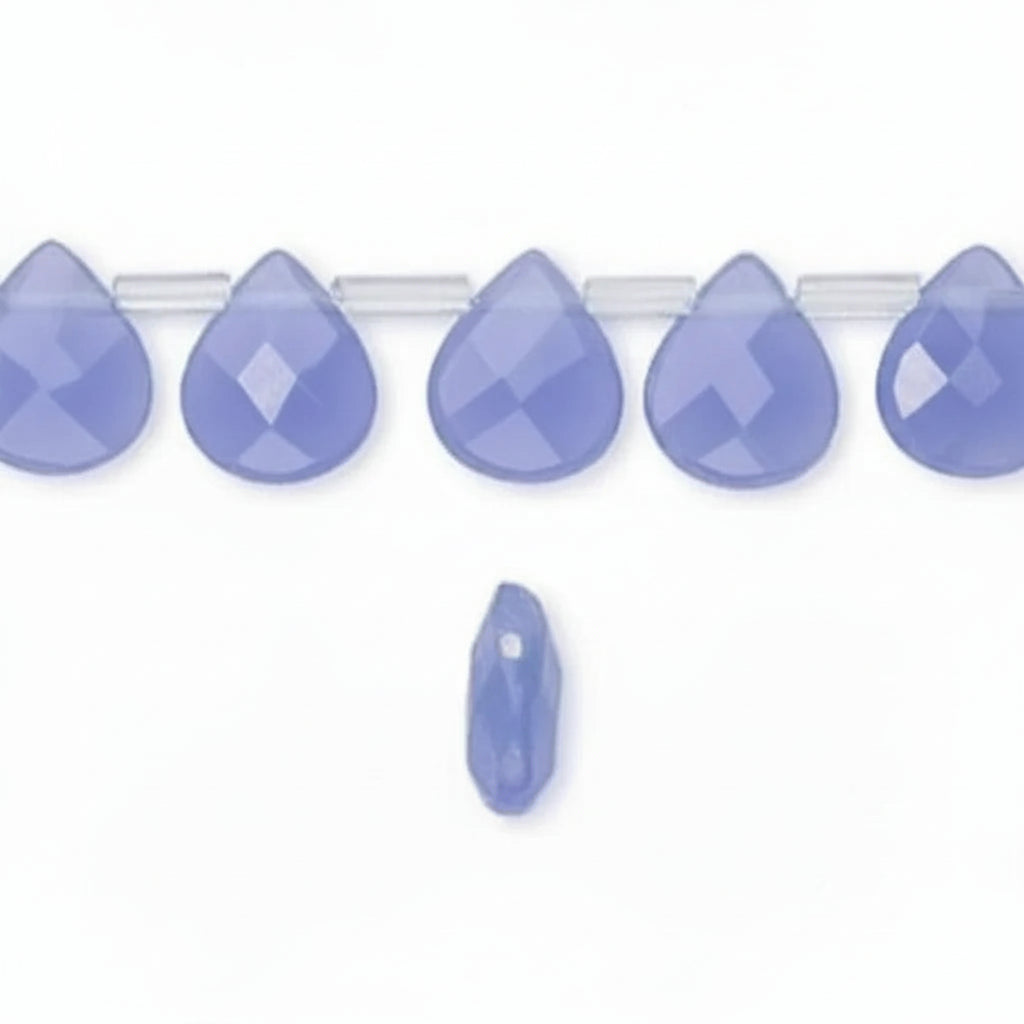 Faceted teardrop-shaped beads in a dusty periwinkle blue color, shown on a clear strand with one additional bead below, on a white background.
