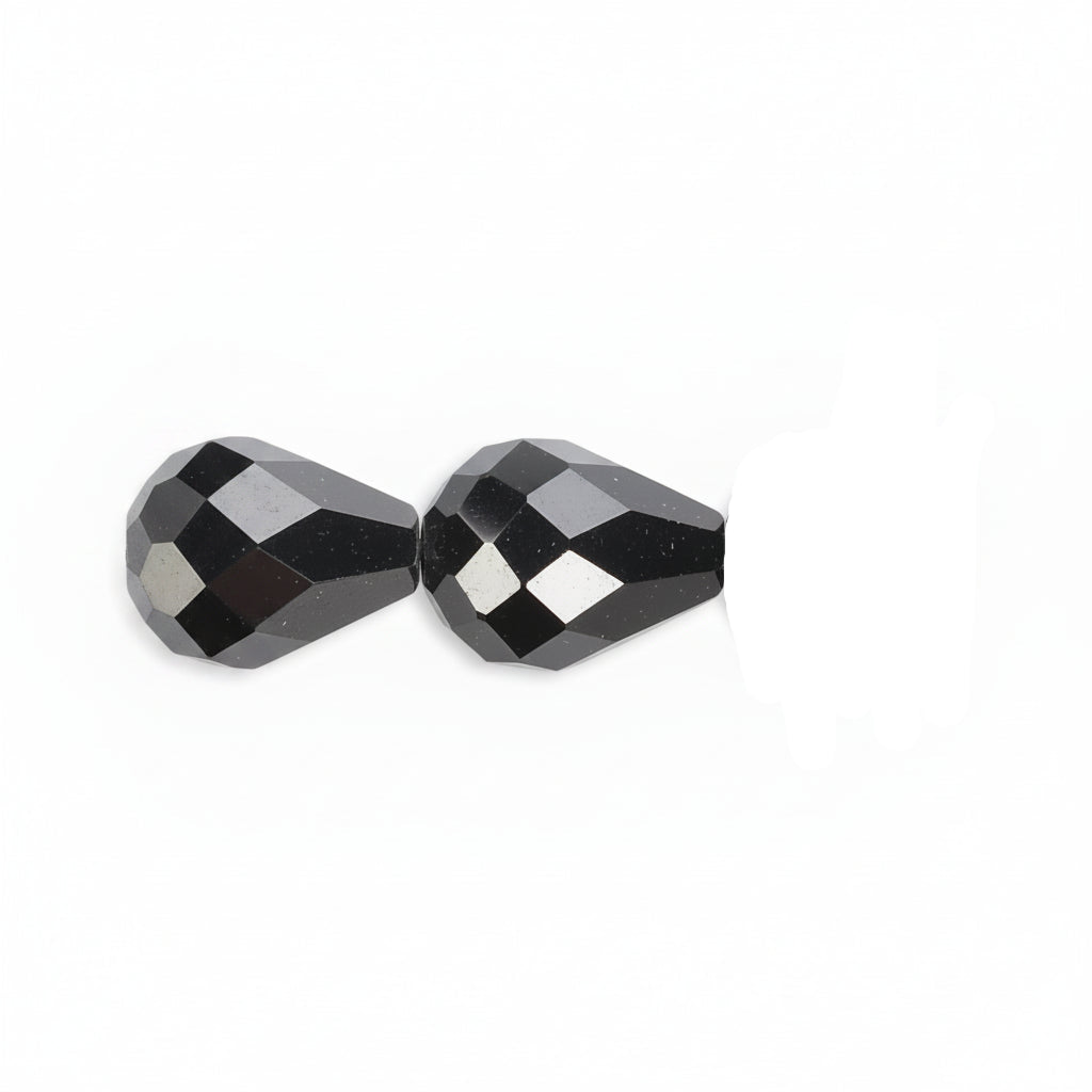 Faceted black glass beads shown in a close-up horizontal line on a plain white background.