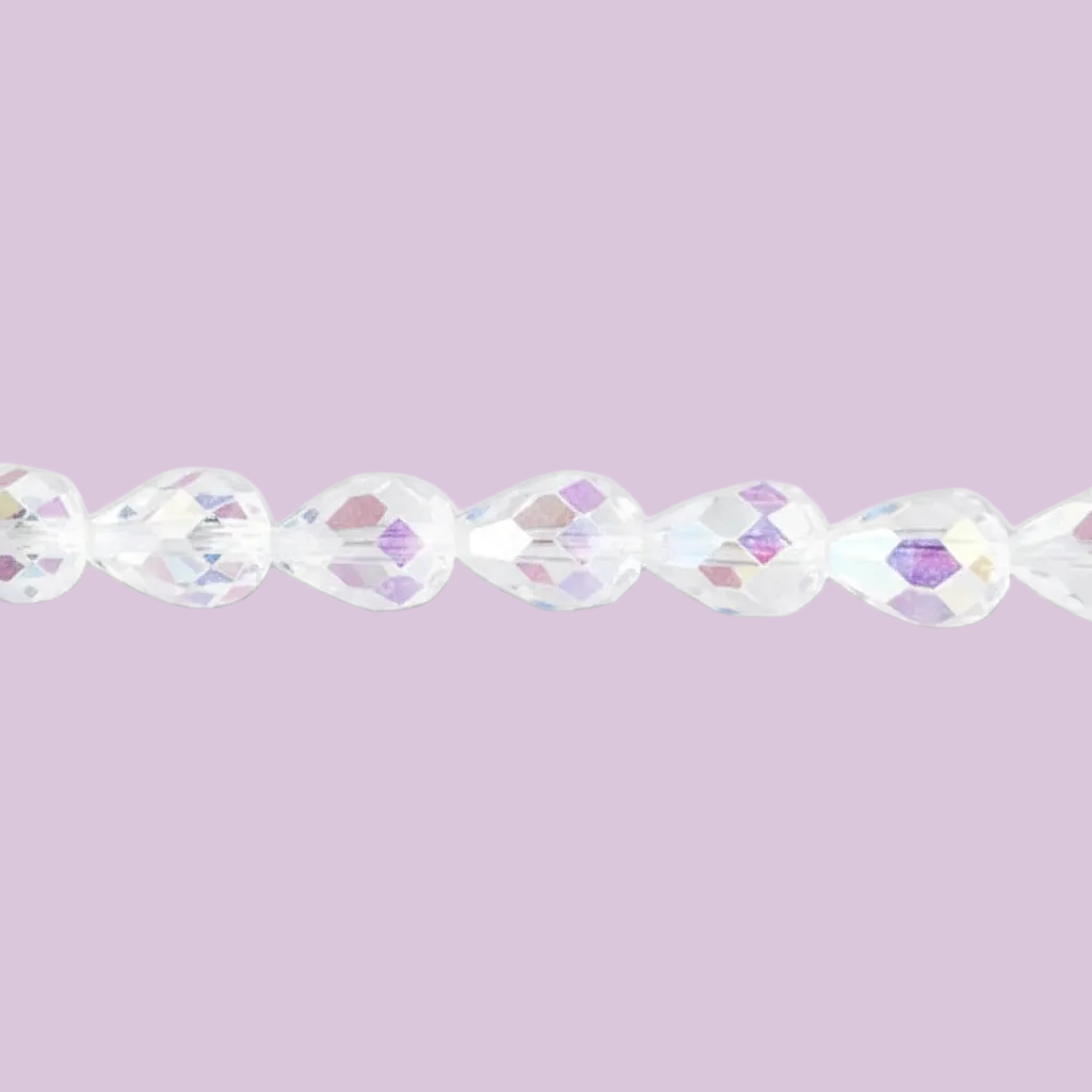 A close-up of faceted clear beads strung horizontally against a solid light lavender background.