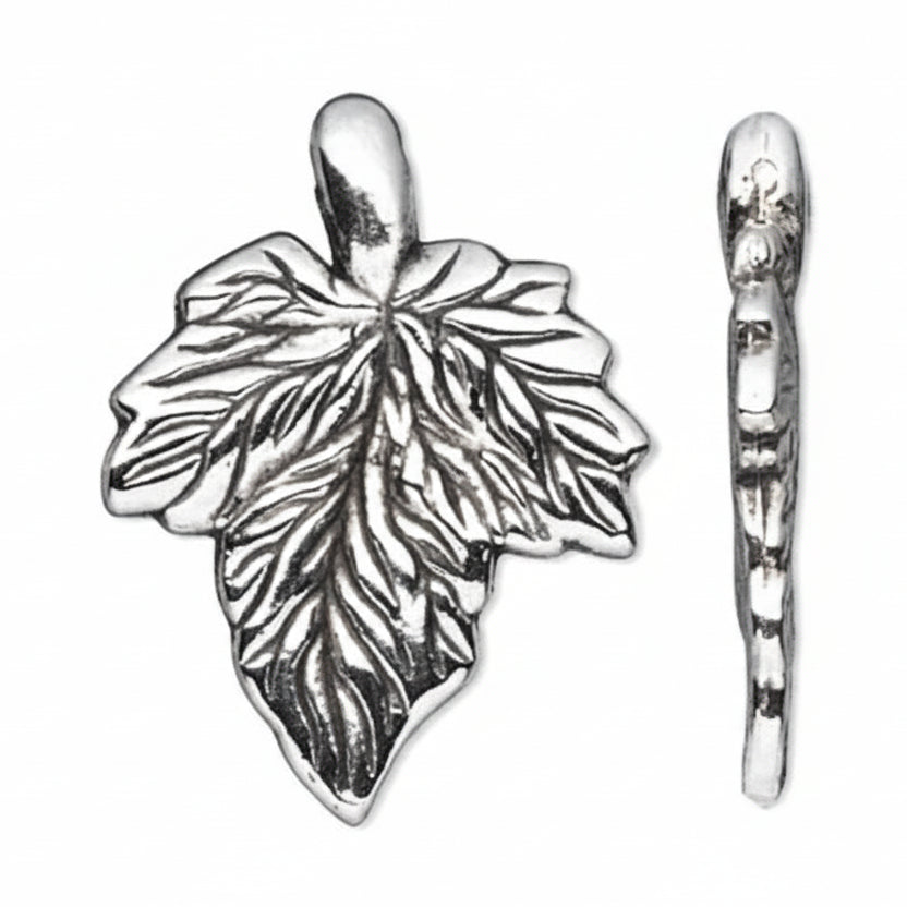 A silver leaf-shaped charm with detailed leaf veins and a hanging loop, shown alongside a side profile view on a plain white background.