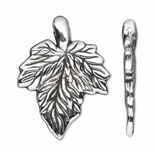 A silver leaf-shaped charm with detailed leaf veins and a hanging loop, shown alongside a side profile view on a plain white background.