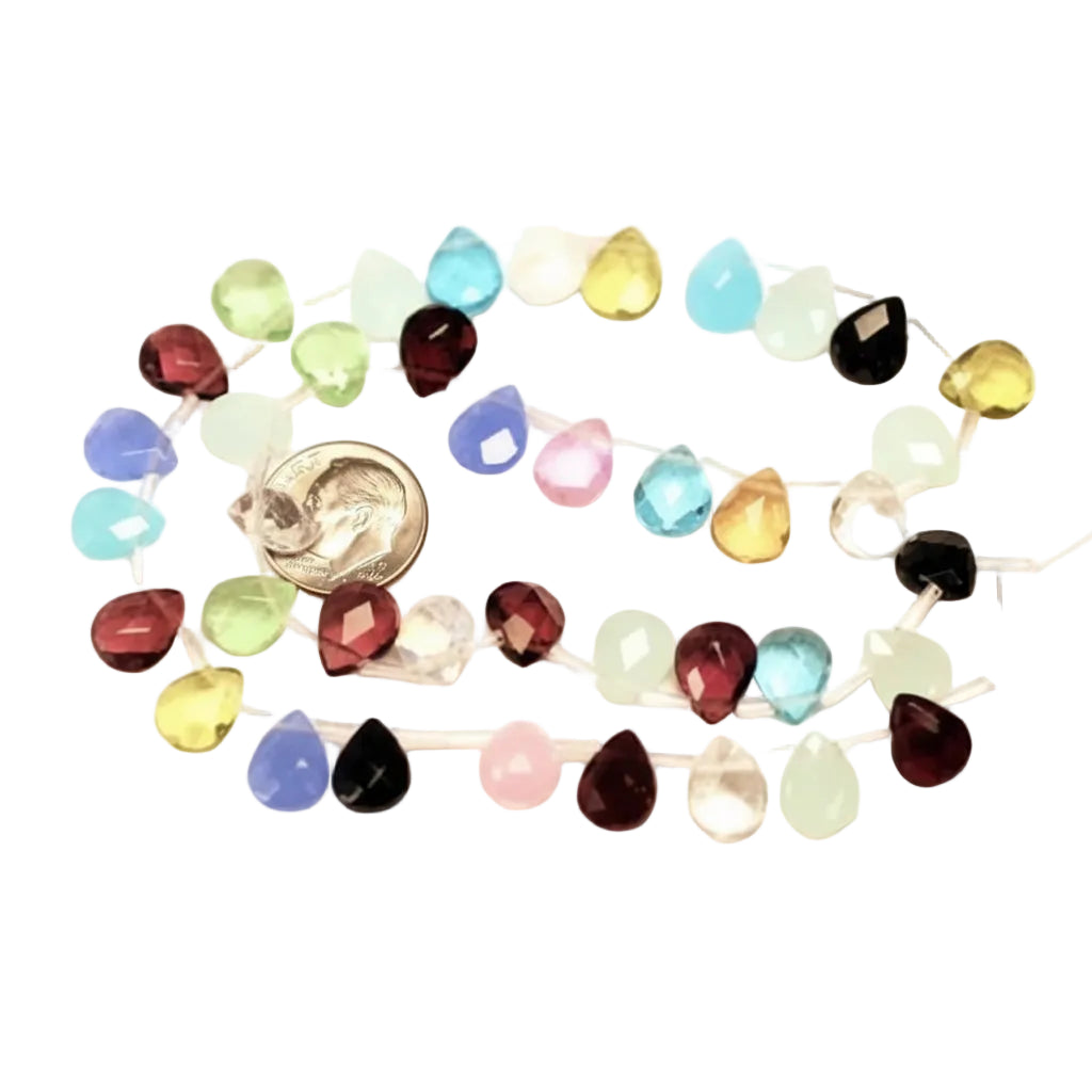 A strand of faceted teardrop-shaped gemstone beads in multiple colors, including blue, green, yellow, pink, red, black, and clear, arranged in a circle with a silver coin for scale on a white background.