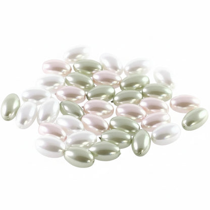 A group of small, glossy, oval-shaped beads in white, pale pink, and metallic olive green, scattered on a plain white background.