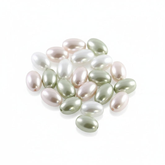 A pile of small, glossy, oval-shaped freshwater pearl beads in assorted colors including pale green, white, and soft pink, arranged on a plain white background.