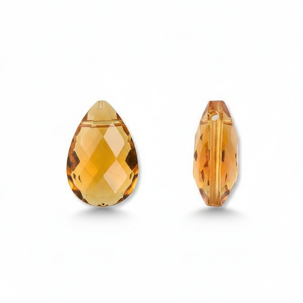 Two faceted teardrop-shaped glass beads shown on a plain white background, one viewed from the front and one from the side. The beads are transparent with a warm yellow-orange color.