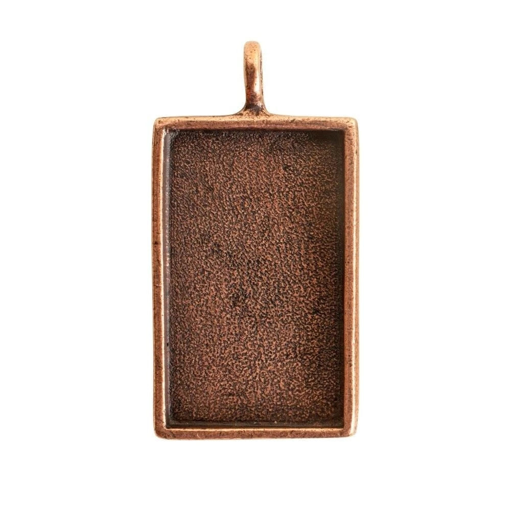 A rectangular copper pendant with a textured, oxidized finish and a small top loop, shown on a plain white background.