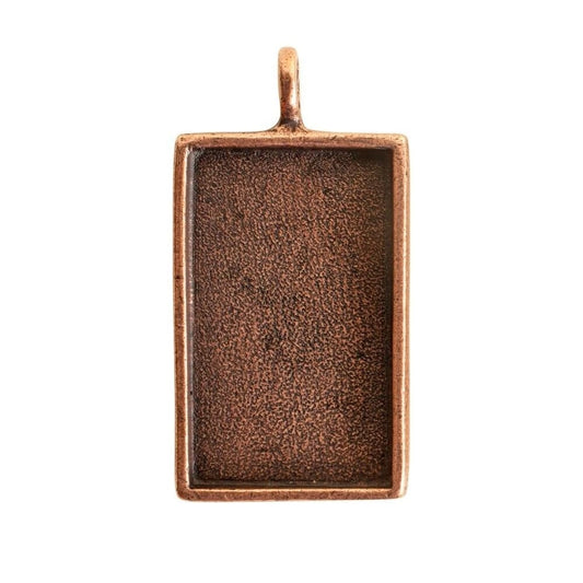 A rectangular copper pendant with a textured, oxidized finish and a small top loop, shown on a plain white background.