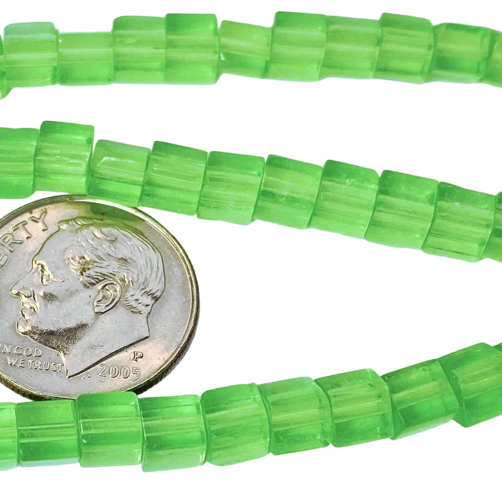 Green translucent rectangular beads strung on a cord, shown with a U.S. dime for scale on a white background.
