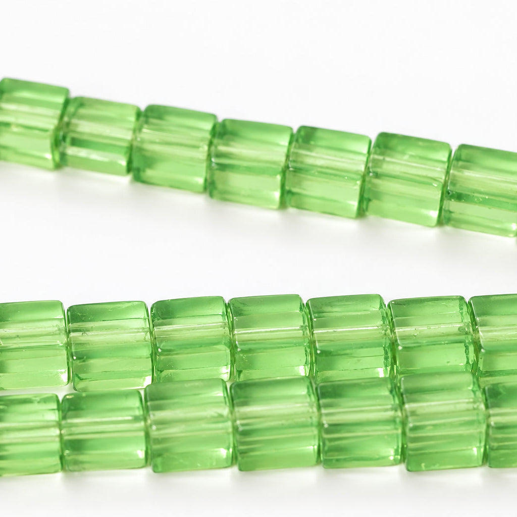 Green translucent rectangular beads strung in diagonal rows on a white background.
