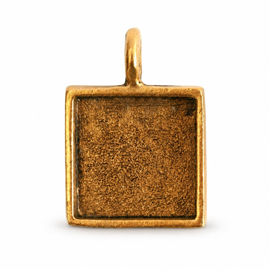 A square gold-toned metal pendant or charm blank with a textured center recess and a small top loop, shown on a plain white background.