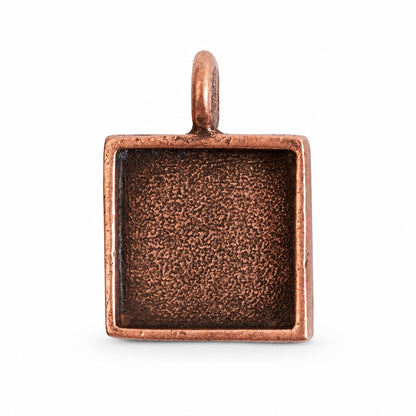A square copper pendant with a textured, oxidized dark interior and a small top loop, shown on a plain white background.