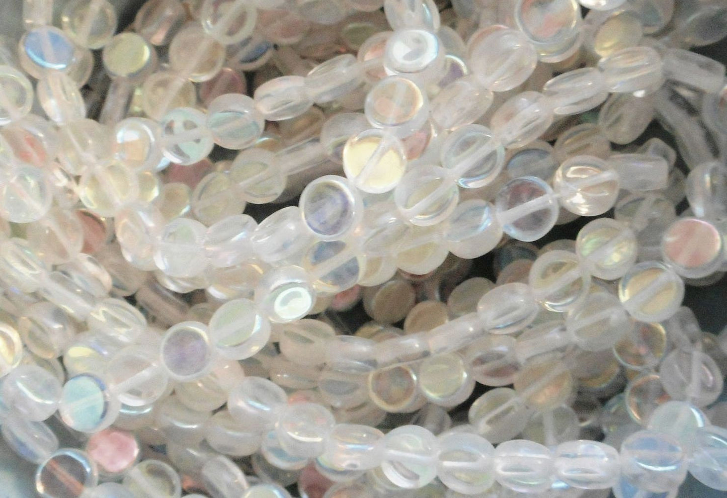 Close-up of translucent beads with iridescent sheen on a light gray background