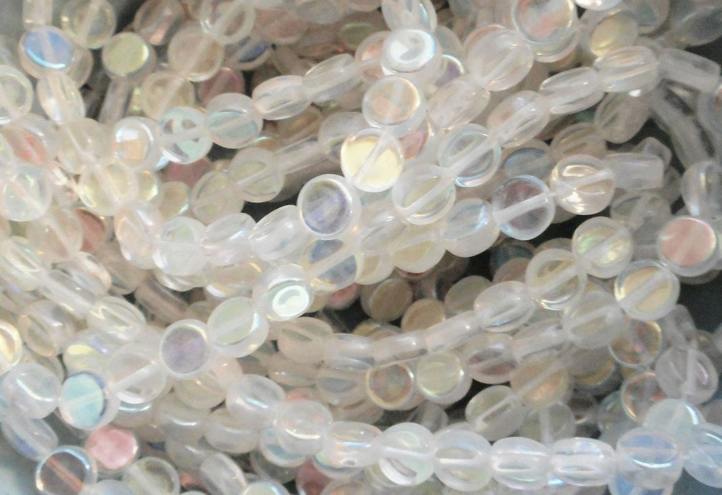 Close-up of translucent beads with iridescent sheen on a light gray background