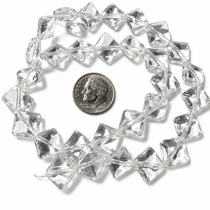 Clear faceted glass beads arranged in a loose circle on a white background, with a coin placed in the center for scale.