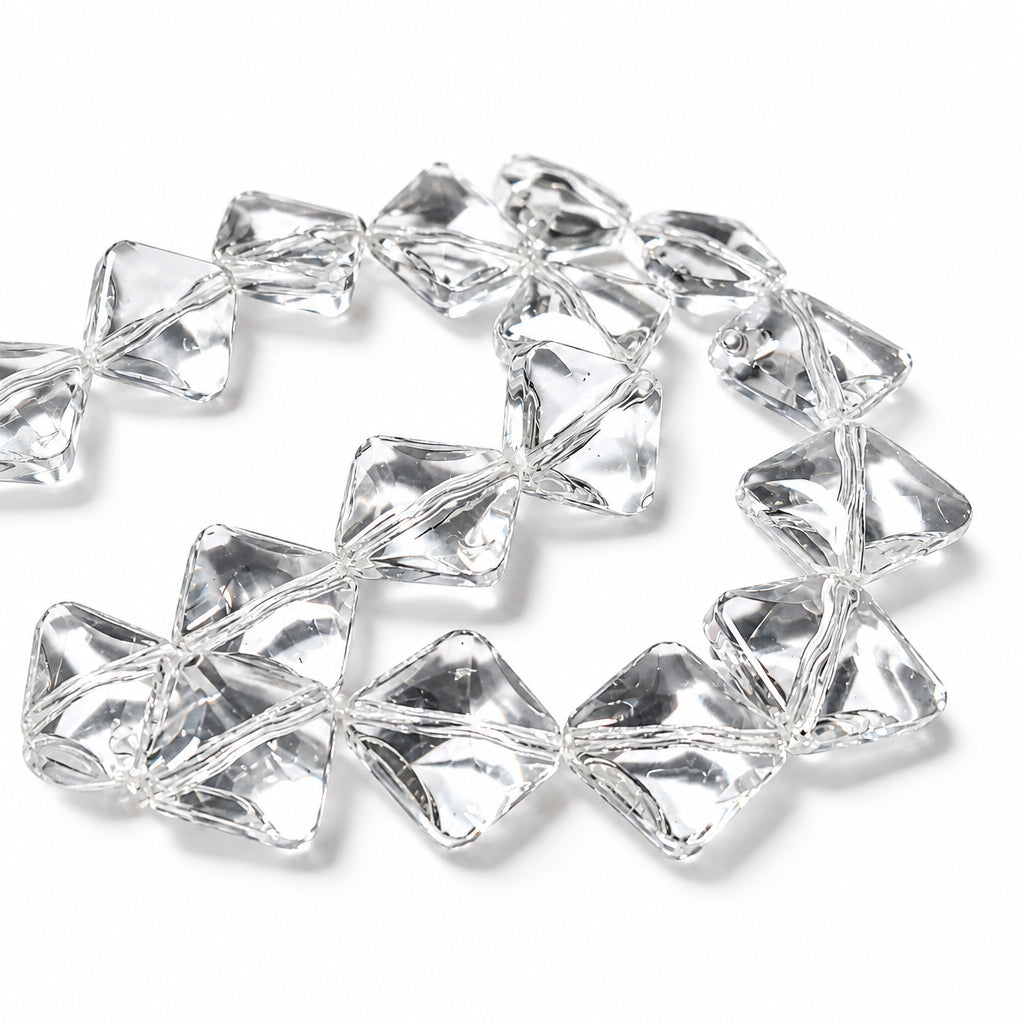 Clear acrylic faceted beads with a geometric, diamond-like shape, arranged in a loose circle on a white background.