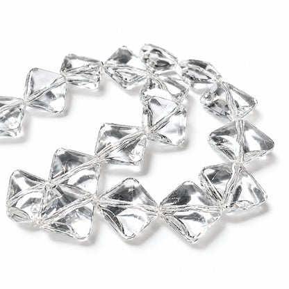 Clear acrylic faceted beads with a geometric, diamond-like shape, arranged in a loose circle on a white background.