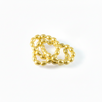 A cluster of shiny gold magnetic beads arranged in a small loop on a clean white background.